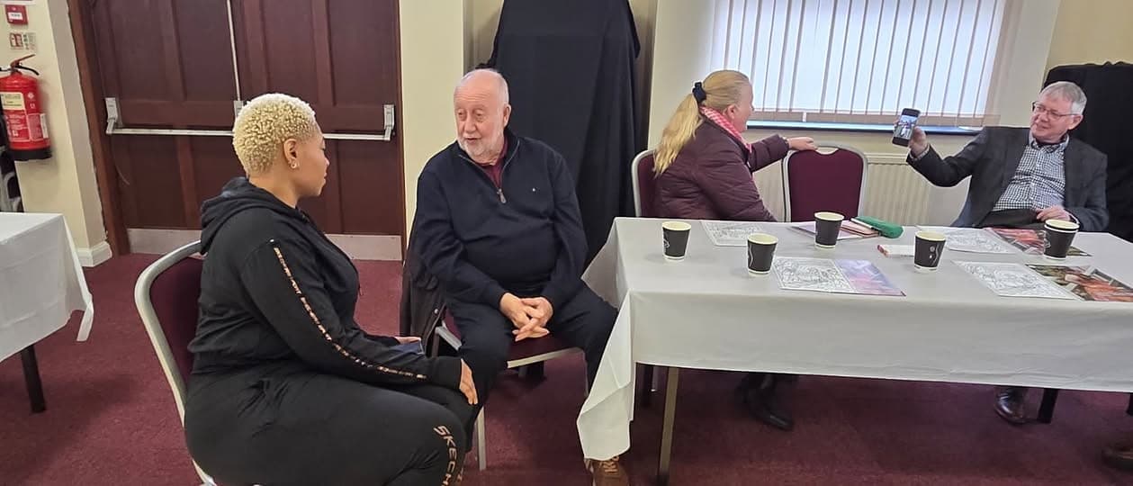 Guests sharing tea and conversation around a table at our Miners Pit Talk